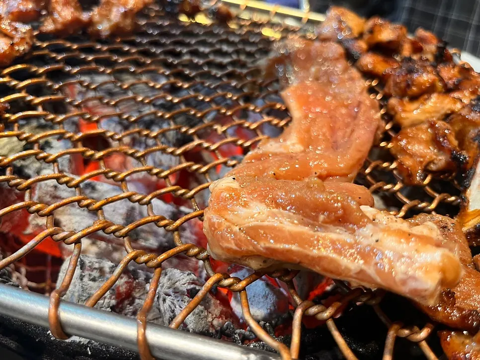 Marinated ribs grilling directly over charcoal