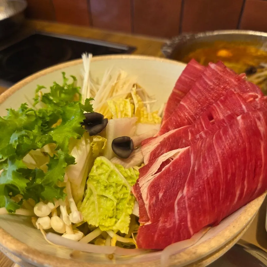 Solo shabu-shabu pot boiling with vegetables added in