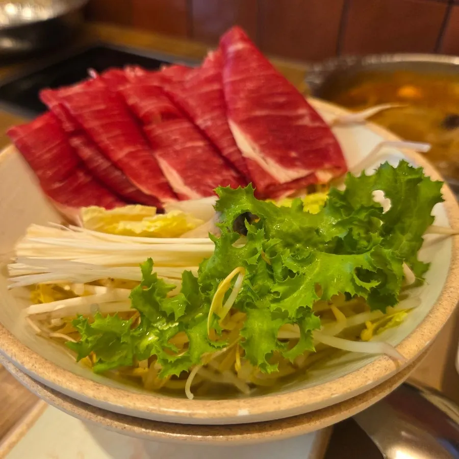Pot full of spicy shabu-shabu loaded with extra vegetables and meat