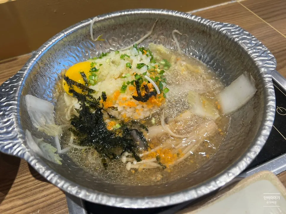 Pot with reduced broth and porridge ingredients cooking