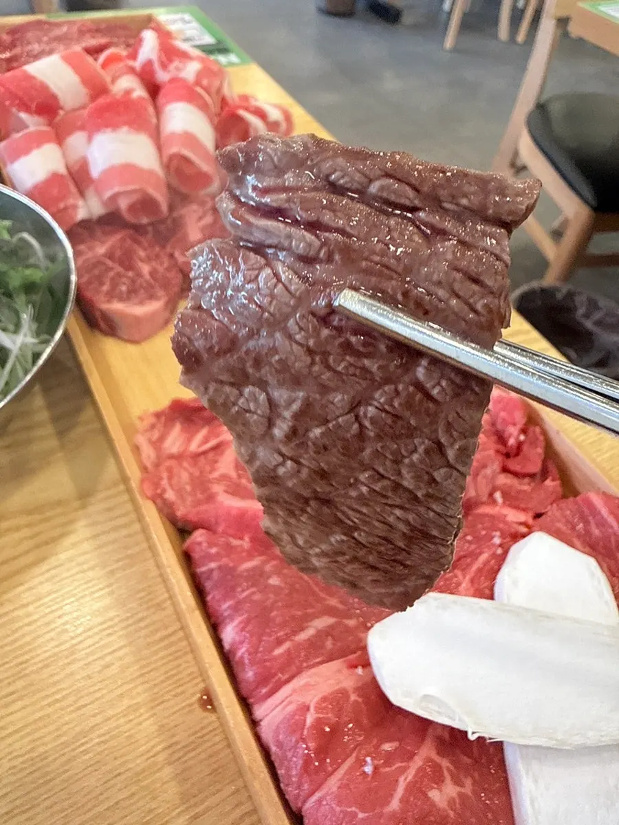 Beef cooking on the grill next to side dishes