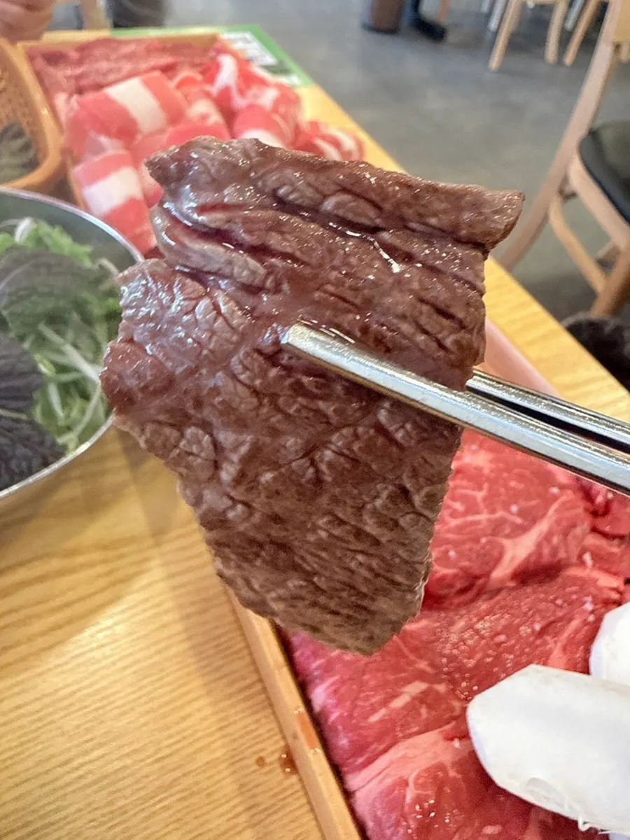 Six cuts of beef laid out on the wide grill plate