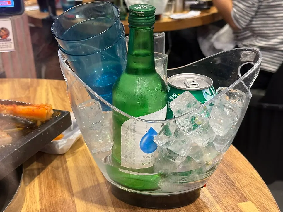 Soju bottle set in an ice bucket packed with ice