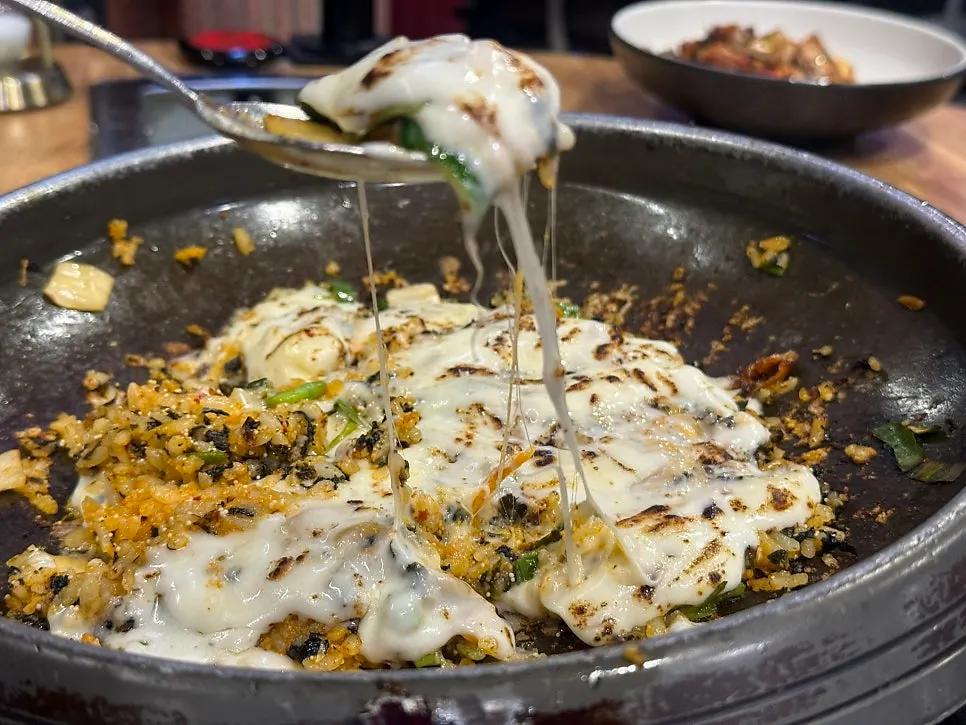 Cheese stretching long from a spoonful of fried rice