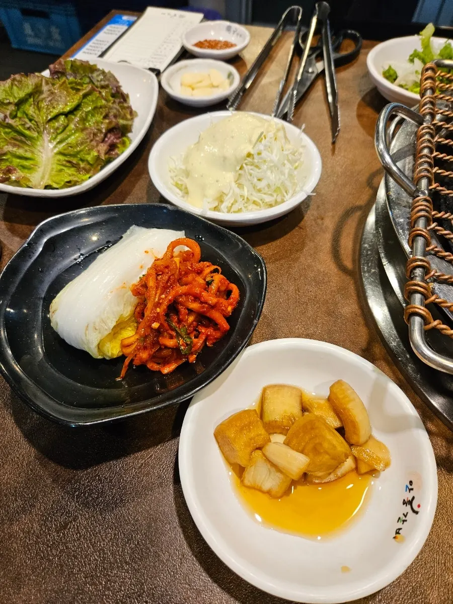쌈야채와 반찬이 깔린 돼지갈비 4인분 상차림