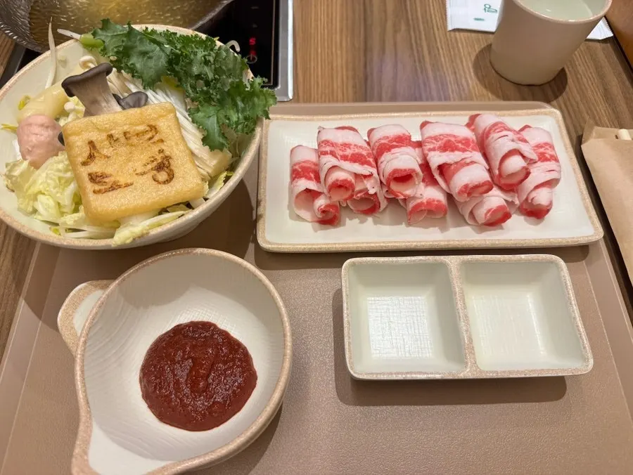Two-person sofa seating with individual induction stoves at Shabu Torang