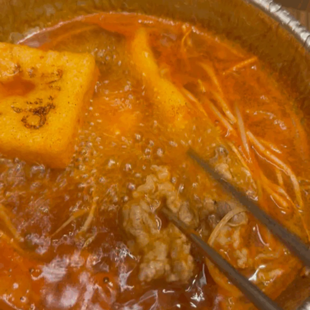 Red shabu-shabu broth after the spicy sauce is stirred in and boiled