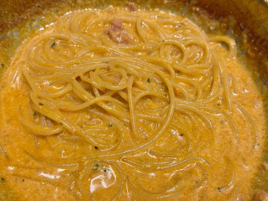 A forkful of thick creamy pasta lifted up