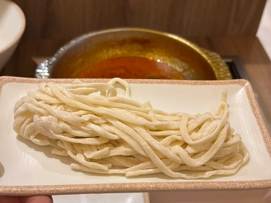 Kalguksu noodles added to the spicy shabu-shabu broth