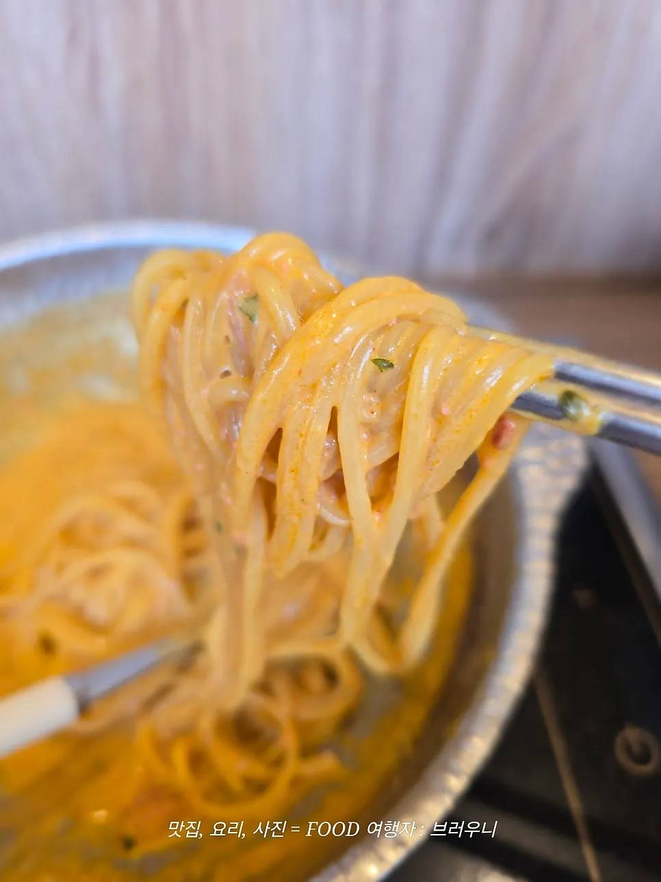 A bite of cream mala pasta with sauce clinging to the noodles