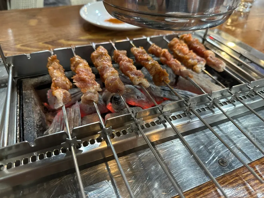 Automatic rotating rail grill over charcoal