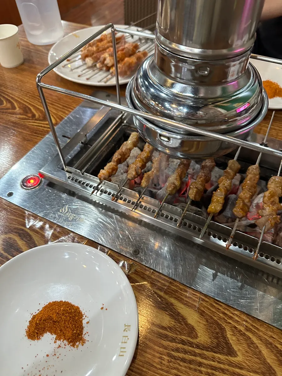 Lamb skewers cooking on the rail