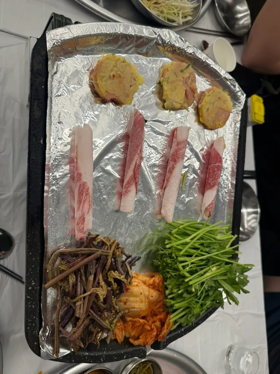 Pork belly grilling with minari and aged kimchi