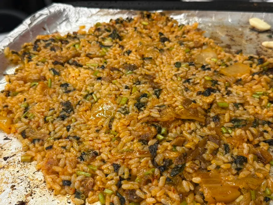 Minari and kimchi fried rice being stir-fried on the grill