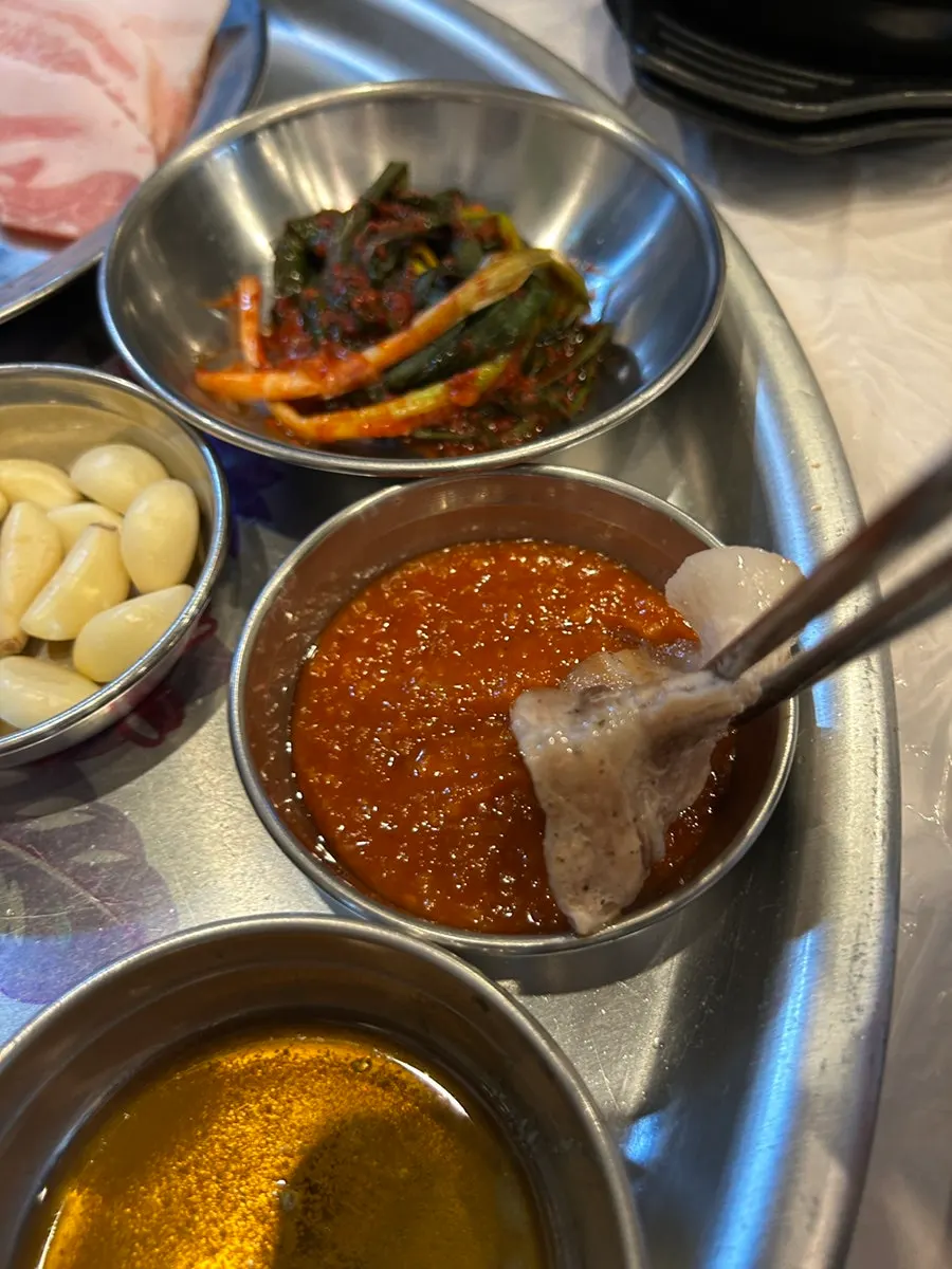 Frozen samgyeopsal dipped in sesame oil sauce