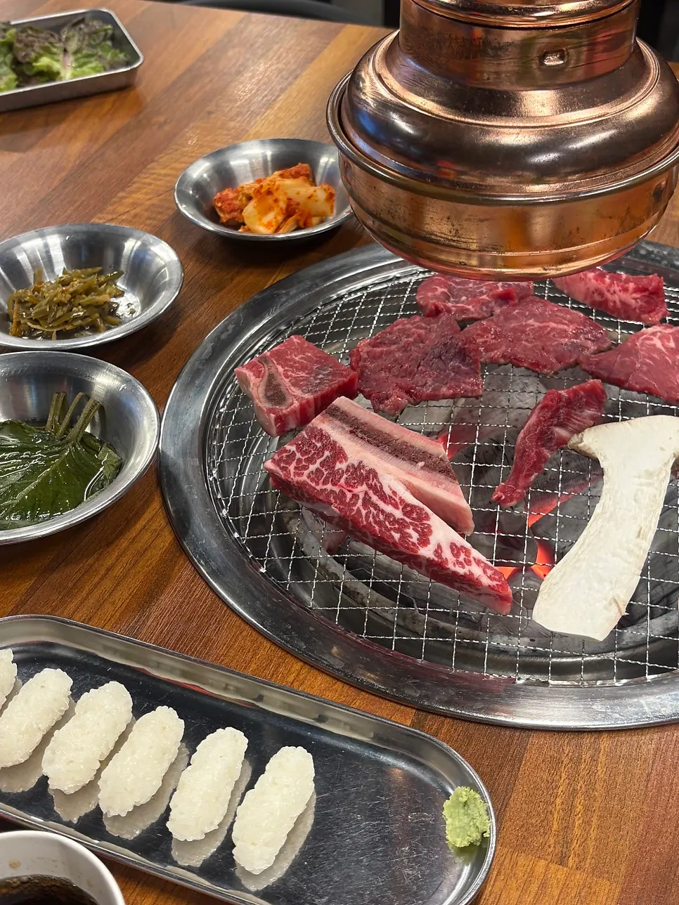 Beef grilling over charcoal at Jowatso