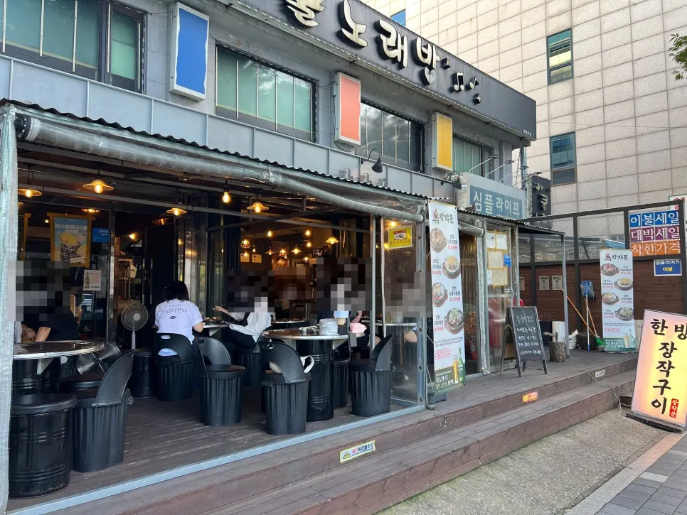 드럼통 의자와 스텐 테이블이 놓인 장작꾼 야장 자리