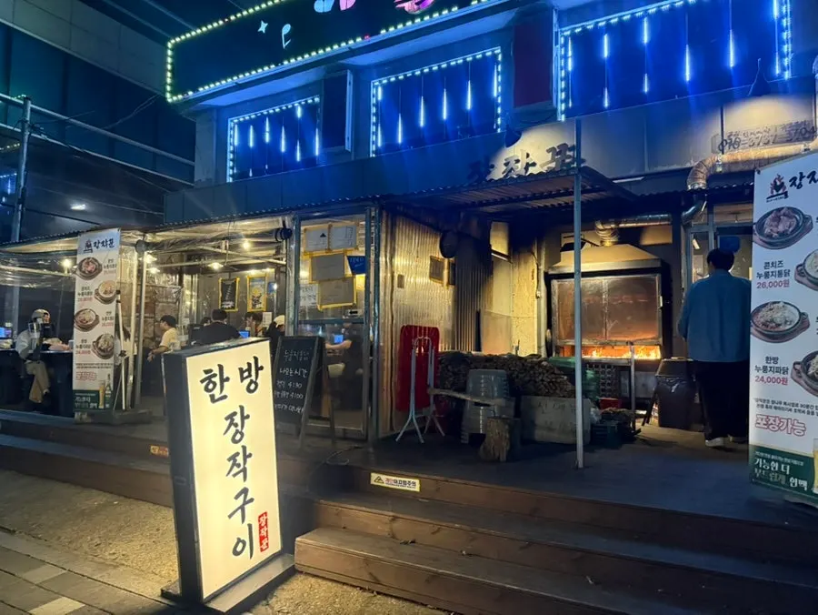 Jangjakgun's outdoor seating lit up in the evening