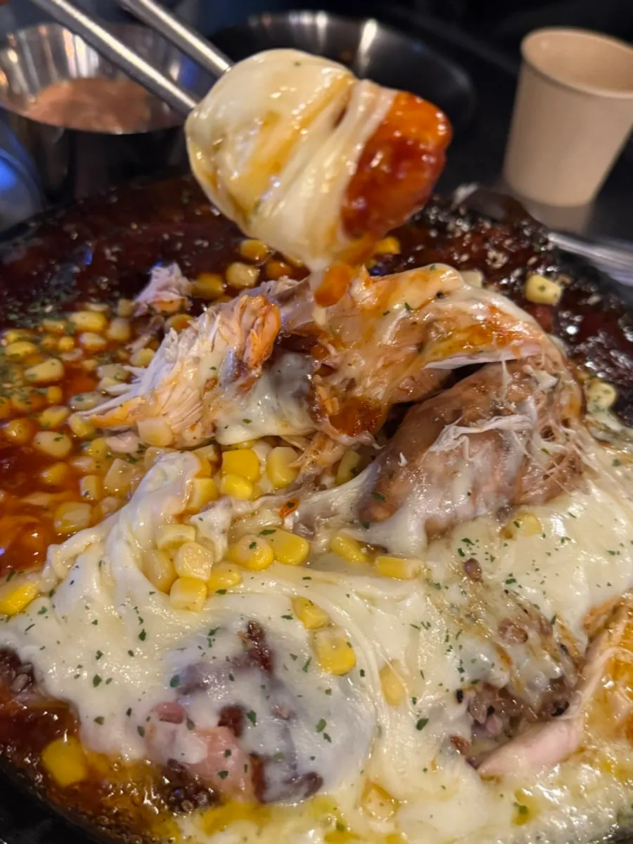 A piece of chicken topped with melted cheese
