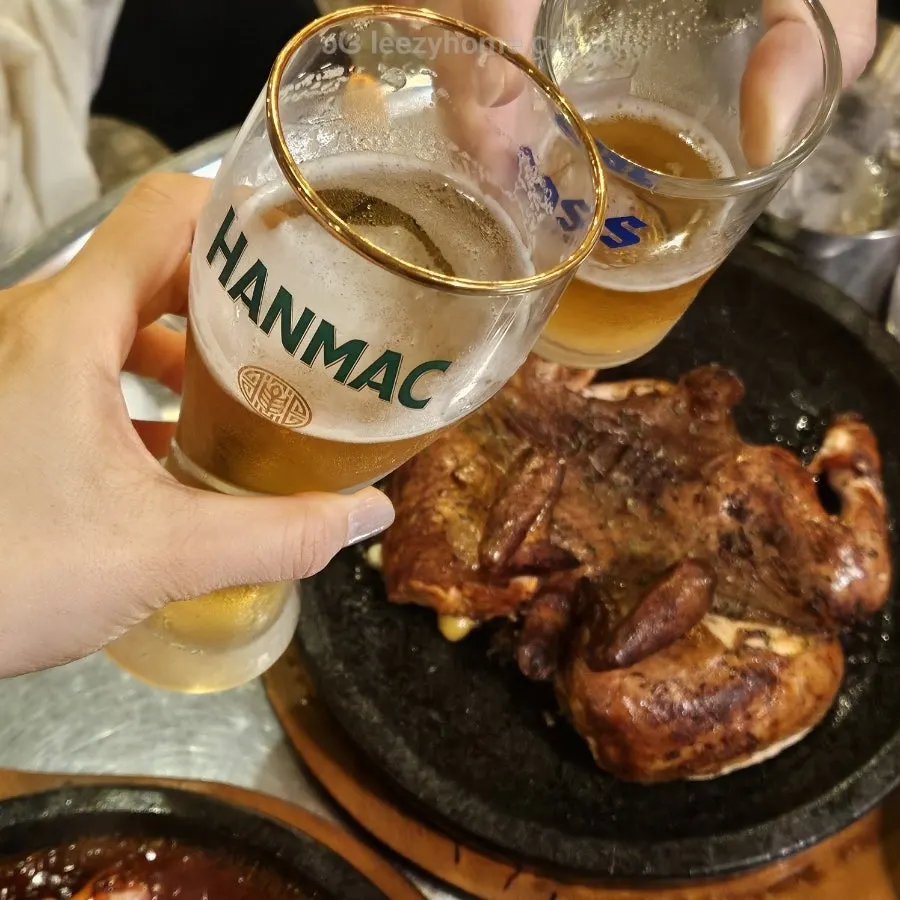 A table with oak-fired whole chicken and beer