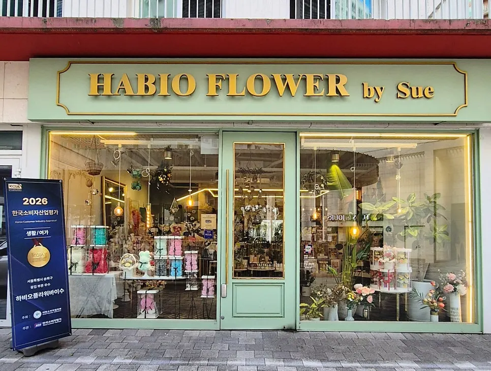 Exterior of Habio Flower by Su with mint walls and a gold sign