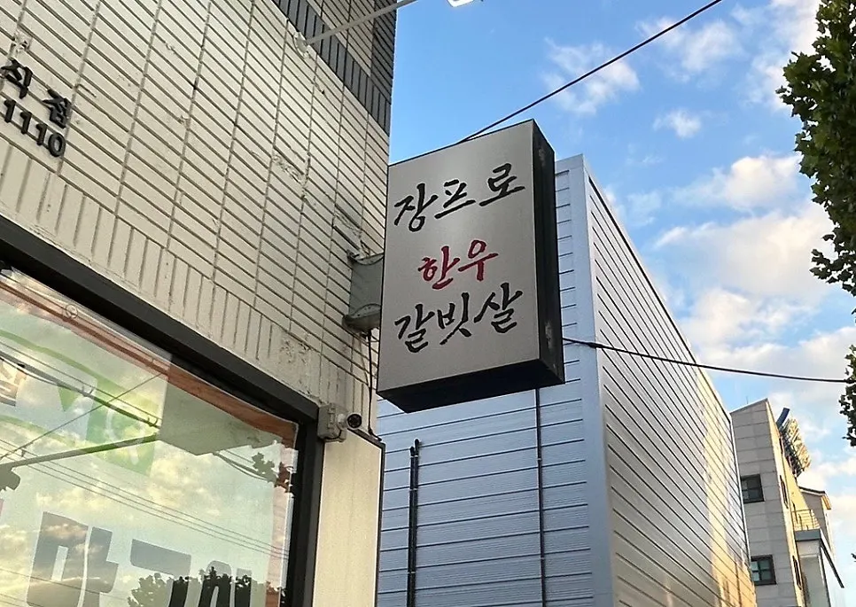 장프로한우갈빗살 간판과 하늘의 구름