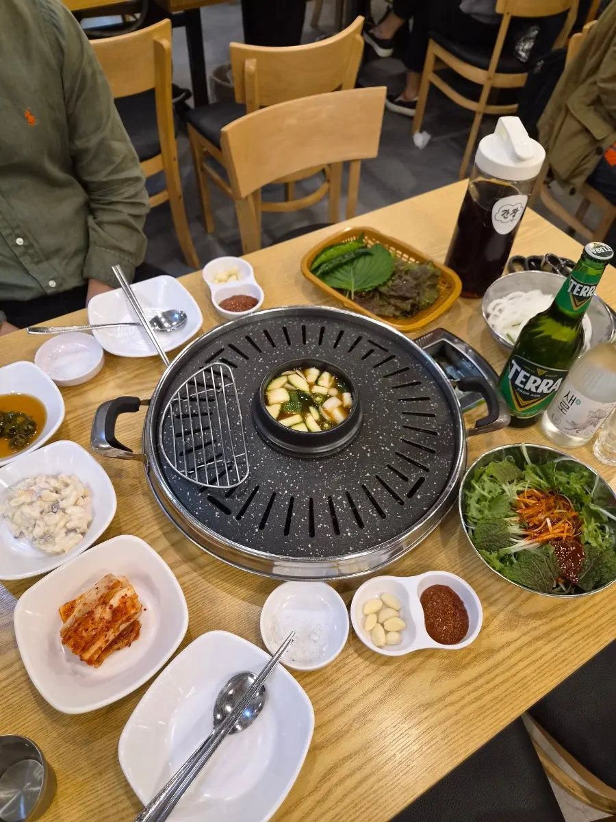 A full table spread with side dishes, sauces, and doenjang jjigae
