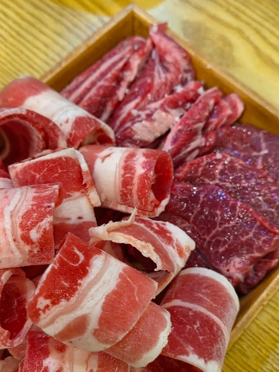 Multiple cuts of beef grilling and being flipped on the grill