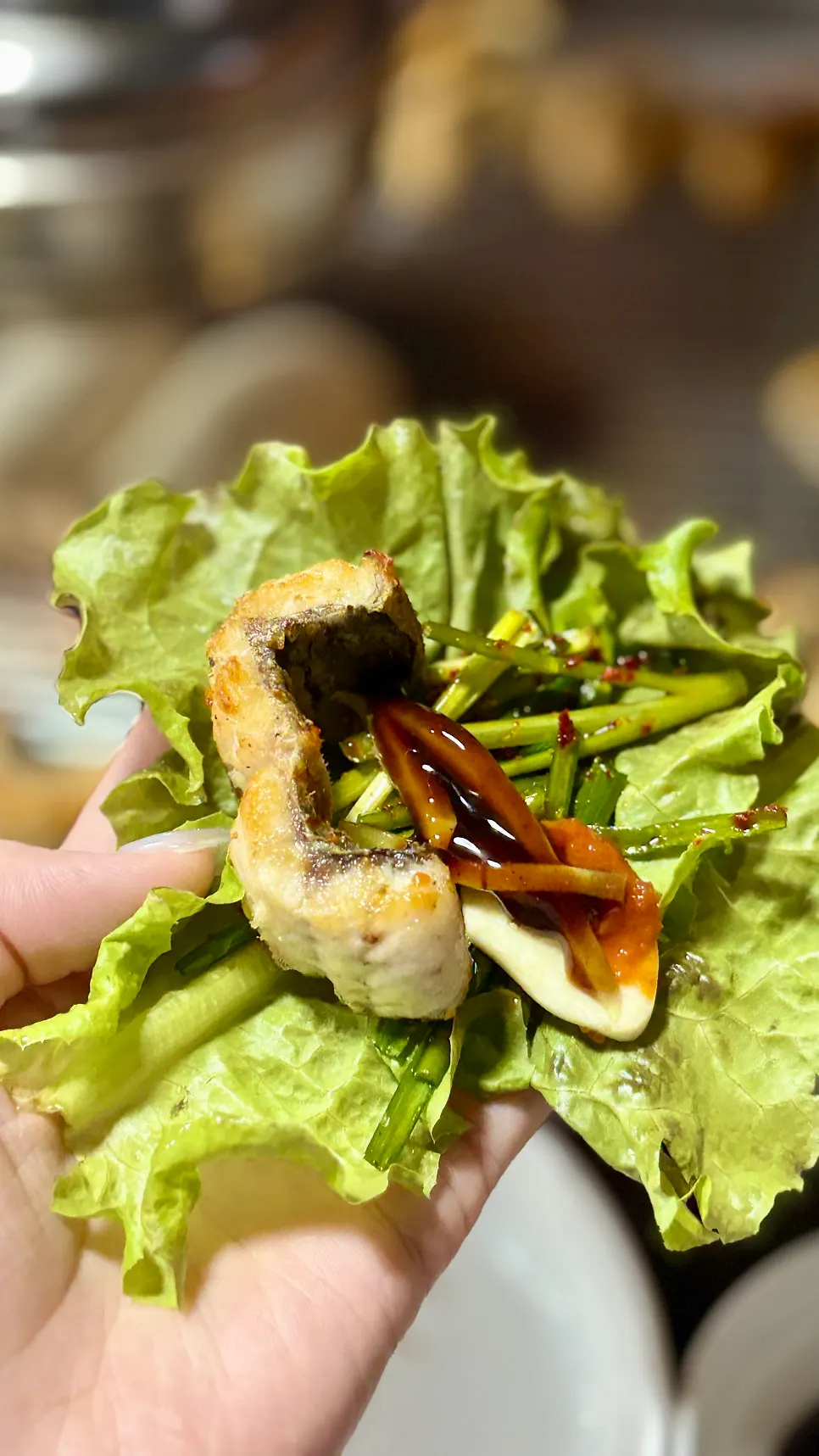 A piece of eel topped with chive salad