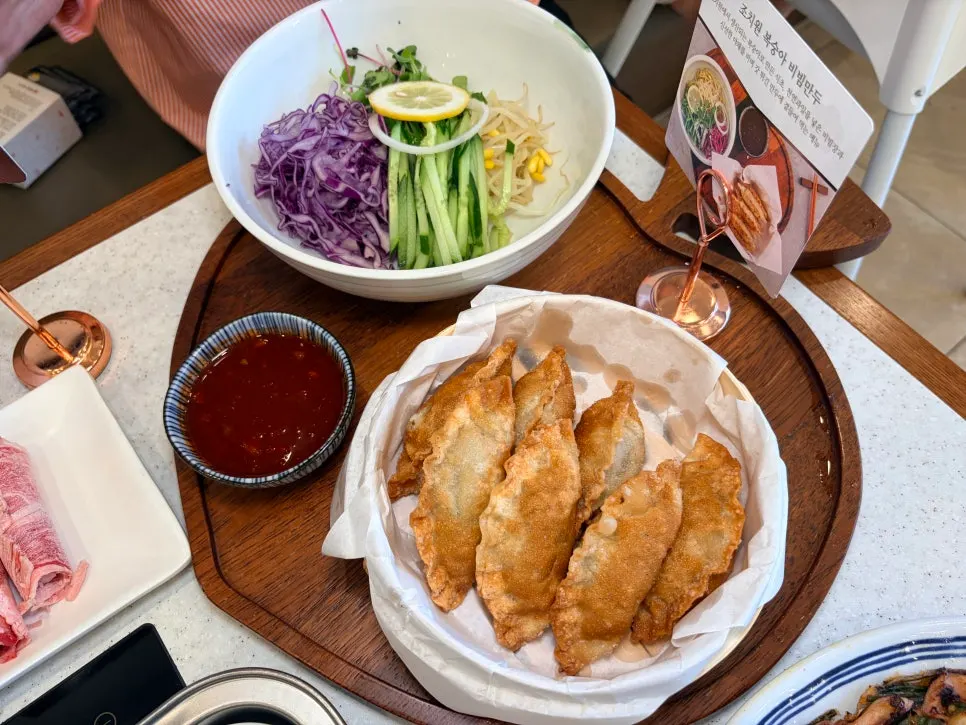 채소와 함께 담긴 복숭아 비빔만두 한 접시