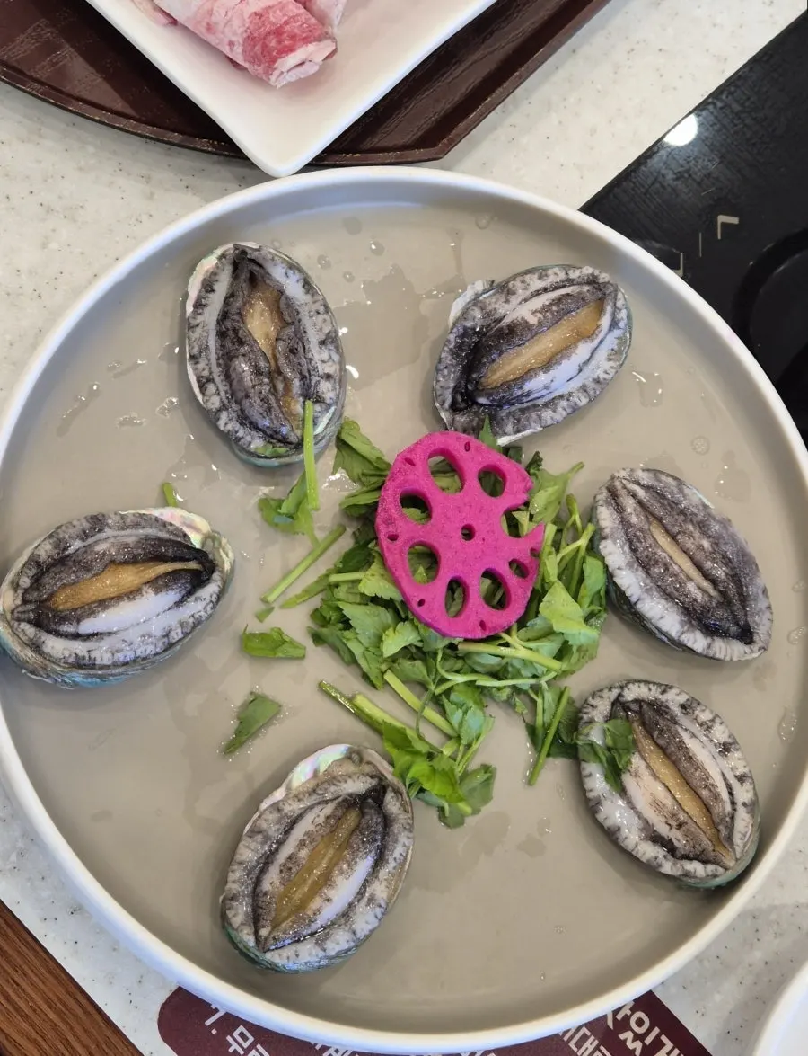 Plating of six live abalone with minari and lotus root