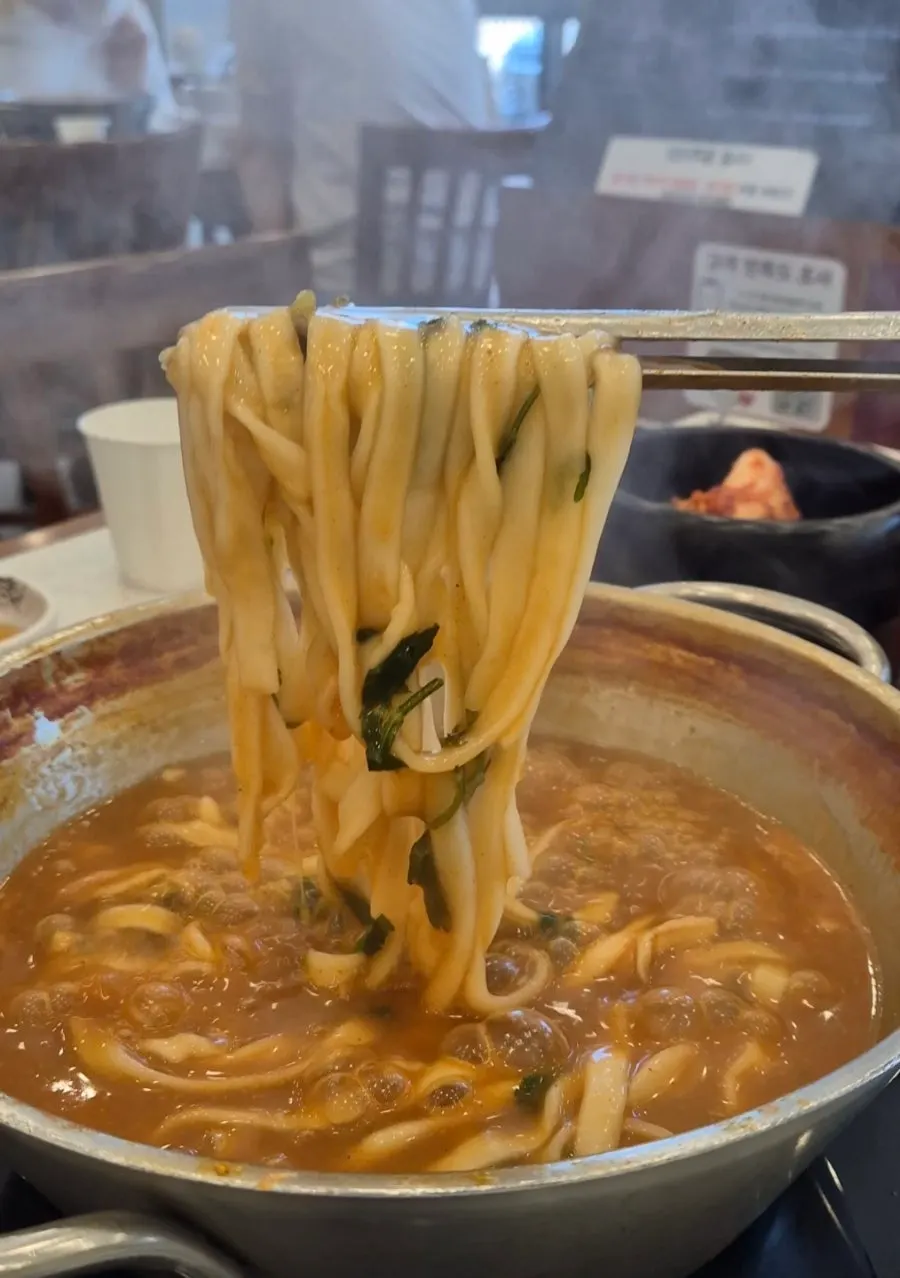 Chewy kalguksu noodles lifted out of the pot