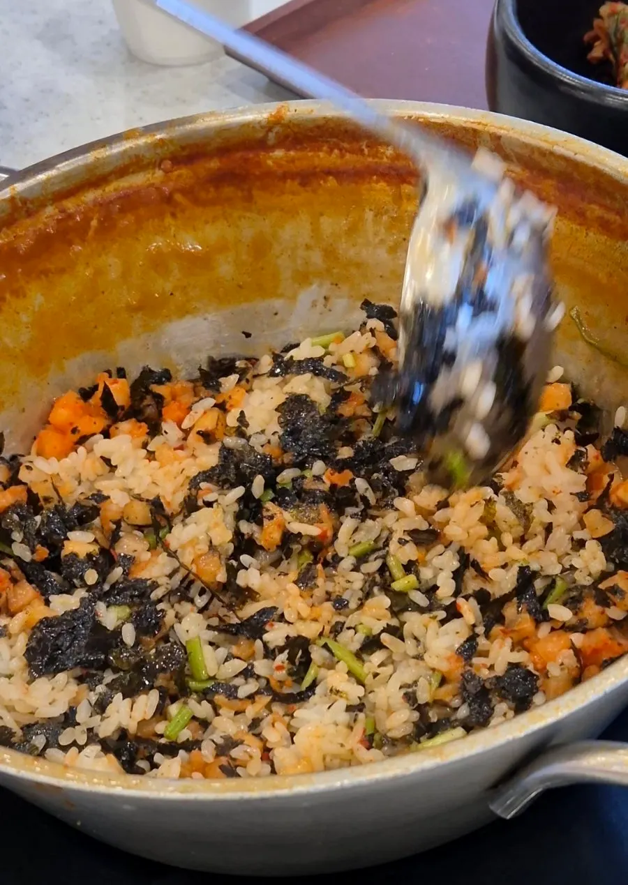 Pouring perilla oil over the fried rice ingredients
