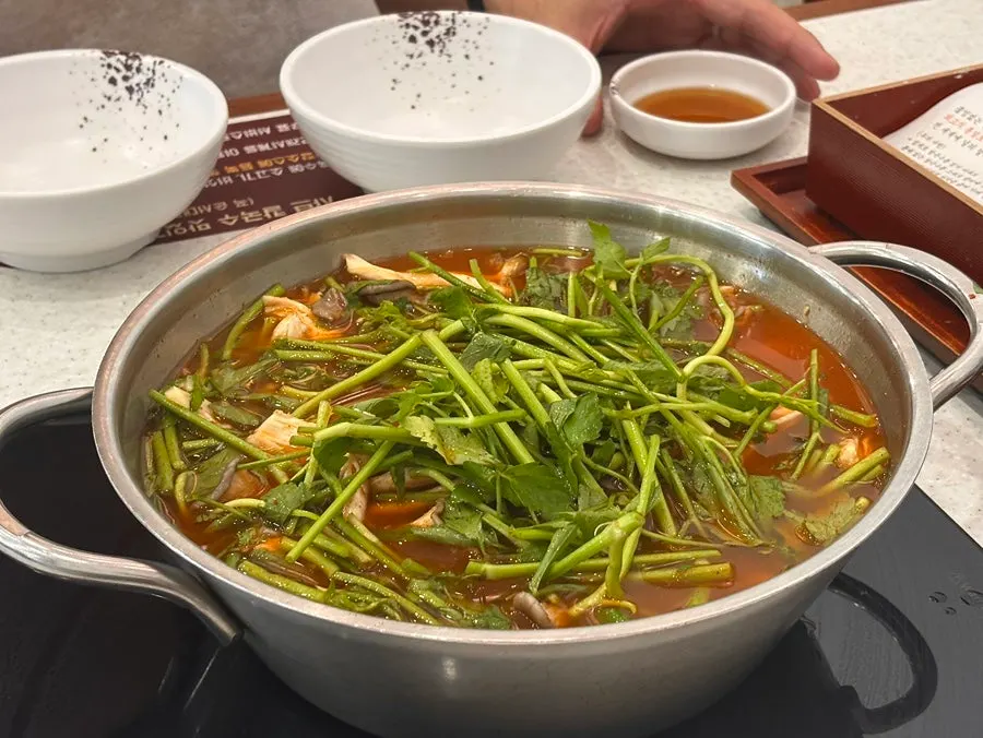 Shabu kalguksu with a chadol-minari wrap piled high with minari