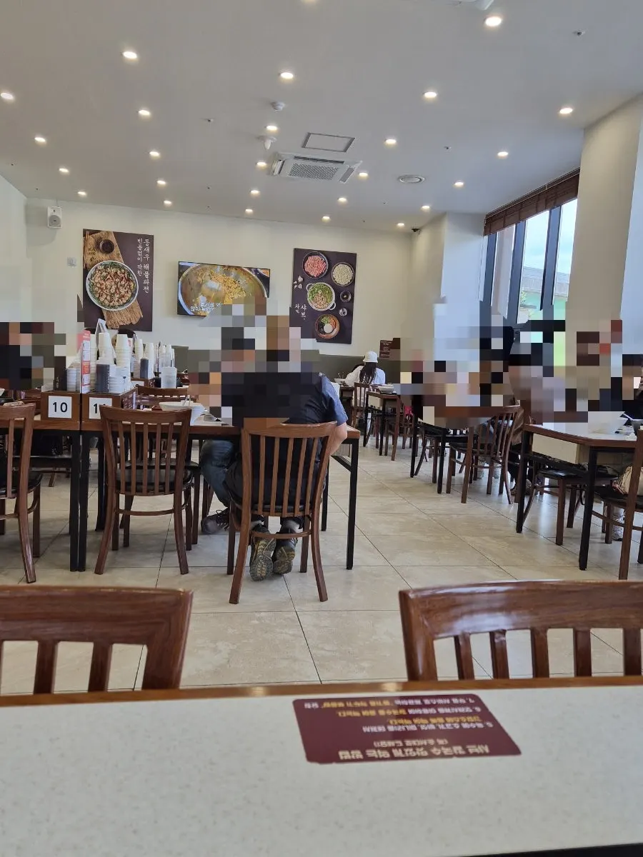 Interior of Jangwongap Kalguksu lit up by floor-to-ceiling windows