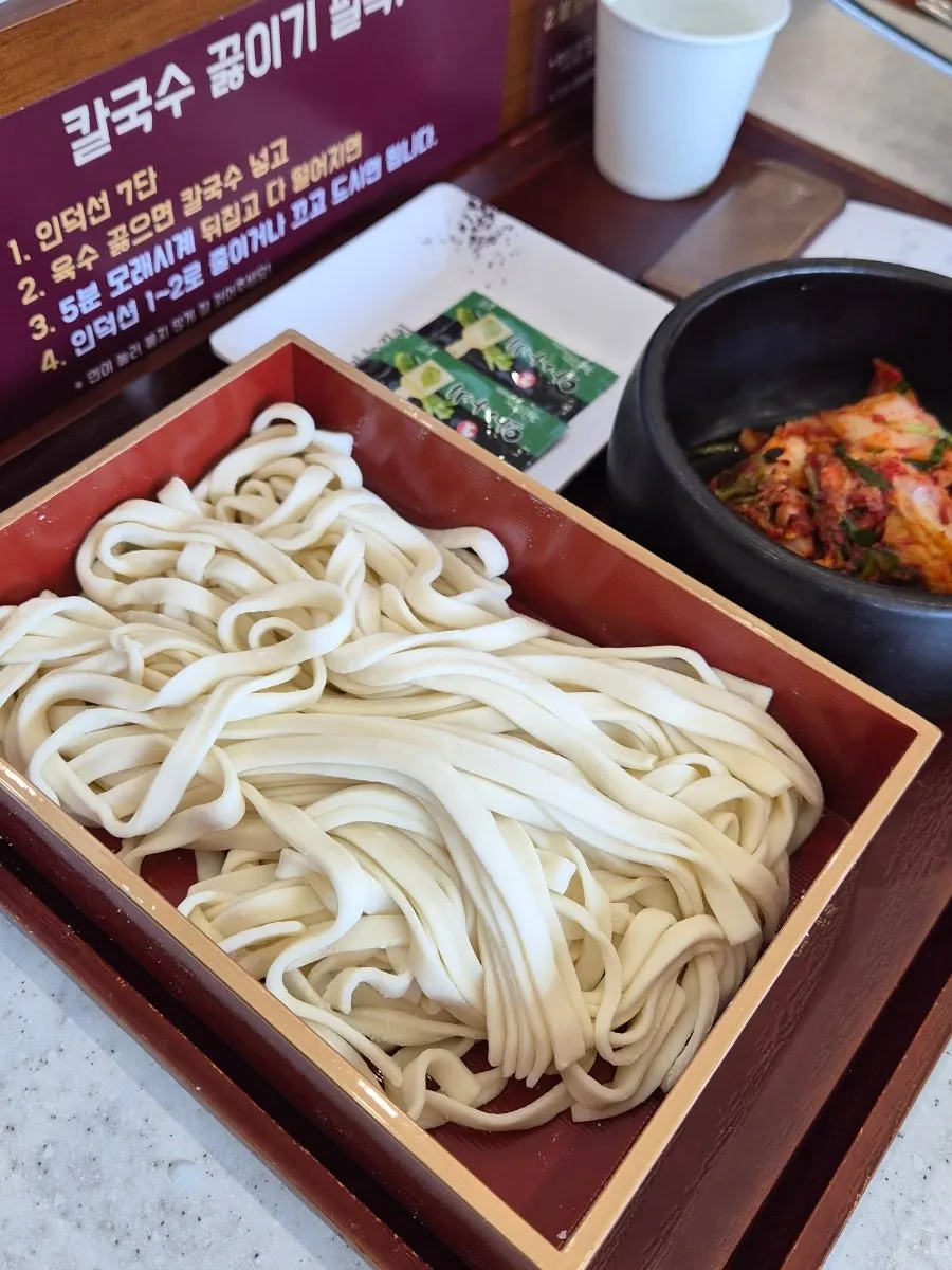 Flat house-made kalguksu noodles added to the broth
