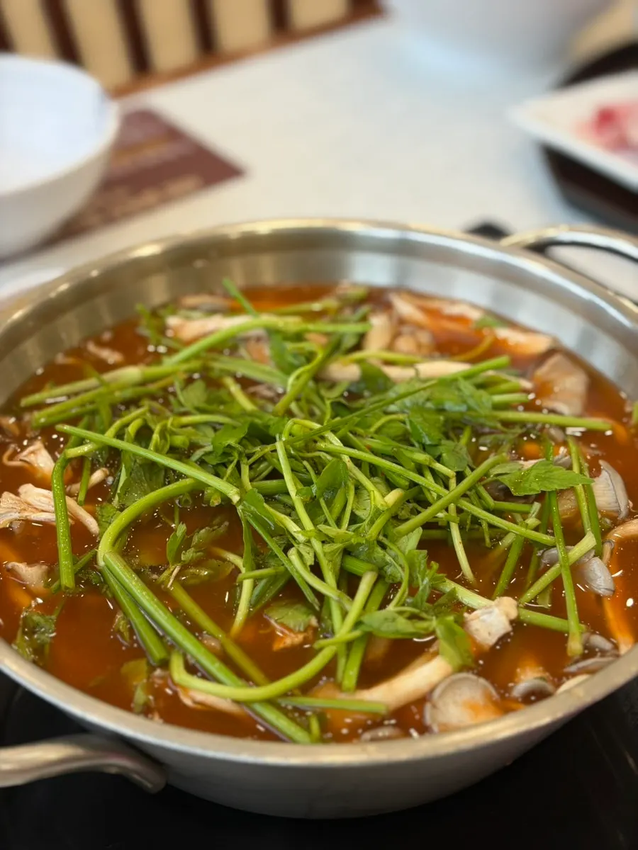 A plate of shabu vegetables with mushrooms and minari