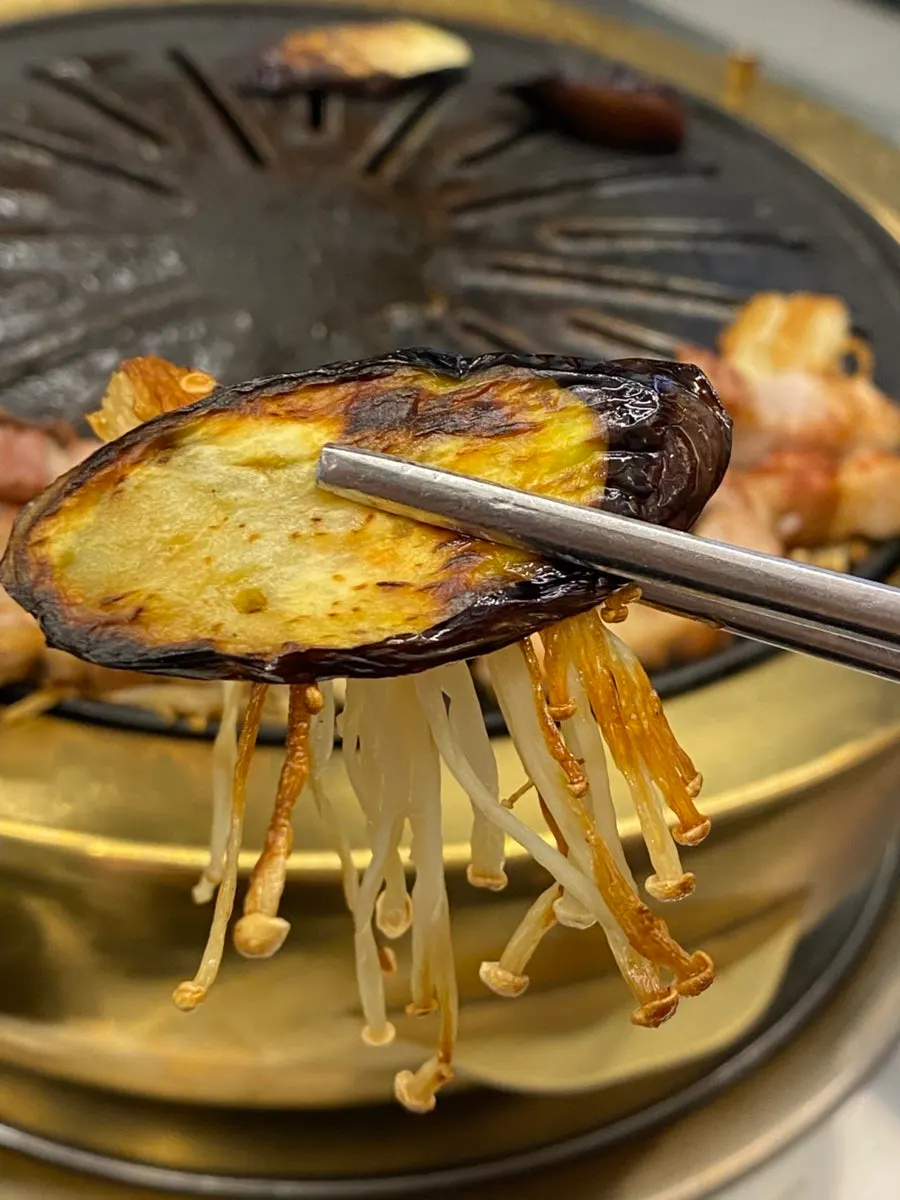 쌈채소에 삼겹살과 마늘을 올린 쌈