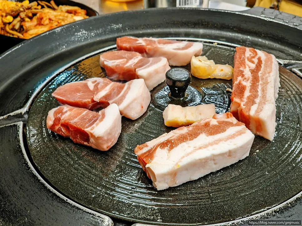 Kimchi, bracken, and bean sprout mix placed on the edge of the iron lid