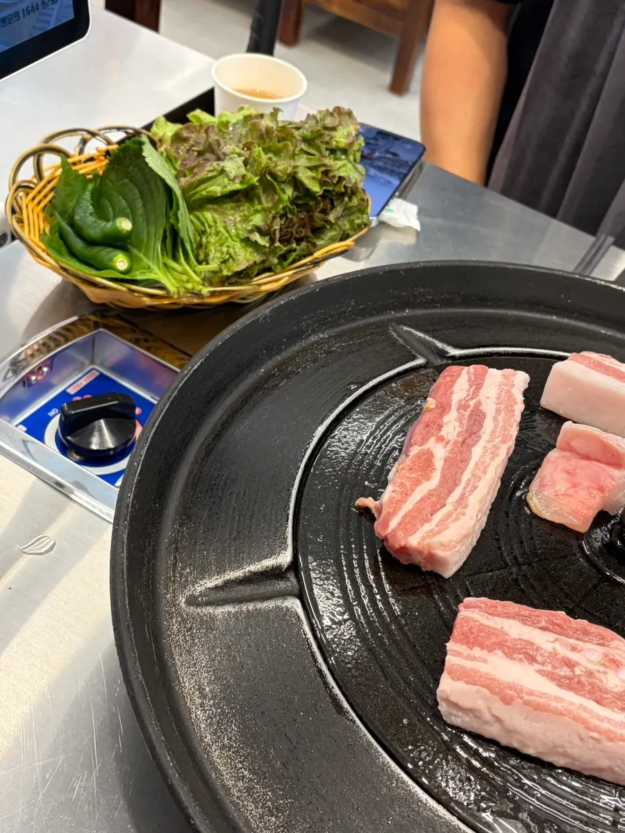 달궈진 솥뚜껑 위에 올린 삼겹살