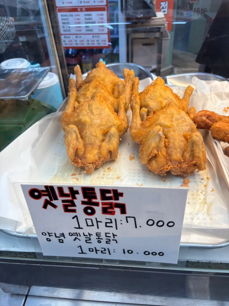 Menu board showing dakgangjeong prices by size