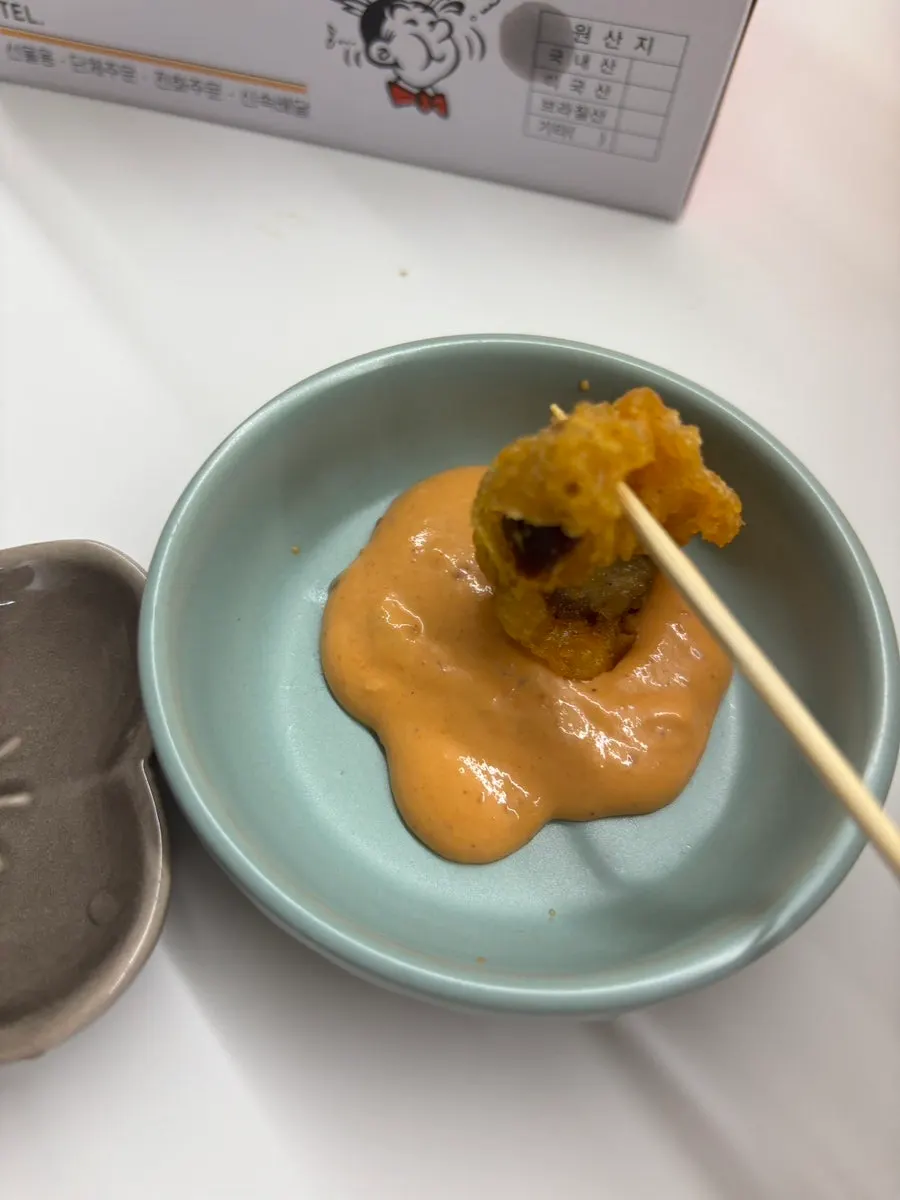 Gizzard fry being dipped in sauce