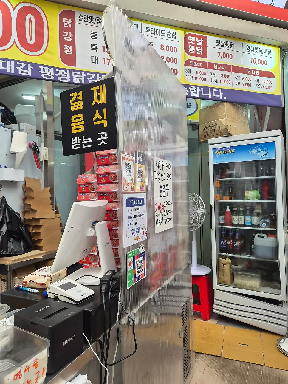 Owner frying chicken next to the order counter