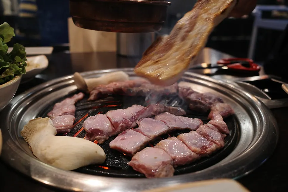 Staff member flipping the meat on the grill