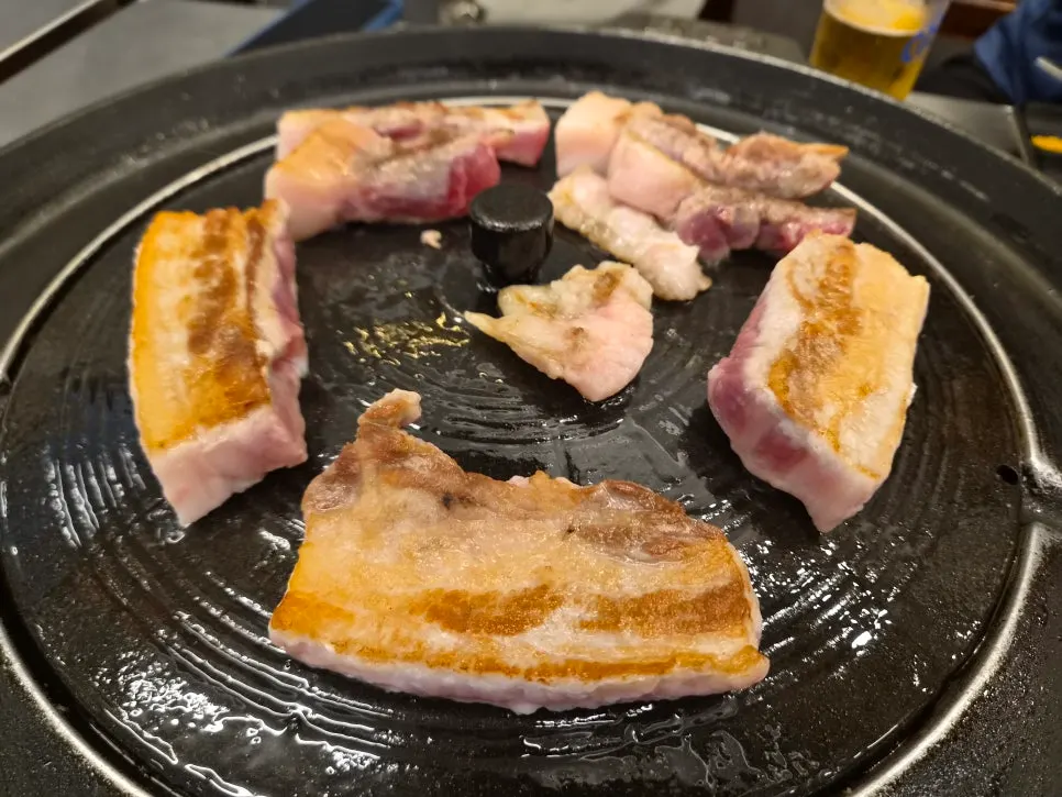 Crispy pork jowl grilled on a pot lid