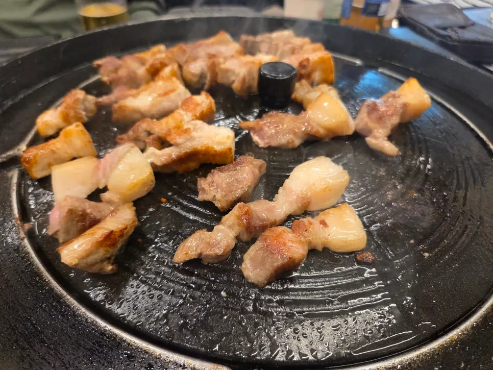 A bite of pork jowl wrapped in fresh leaves