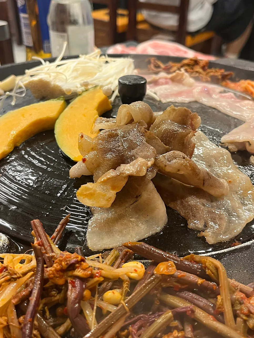 Meat and accompanying vegetables on a pot-lid griddle