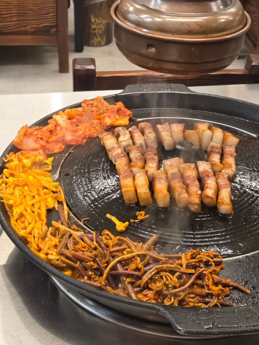 A staff member grilling thick pork belly