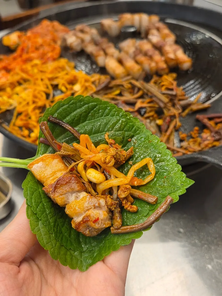 A perilla-leaf wrap topped with pork belly