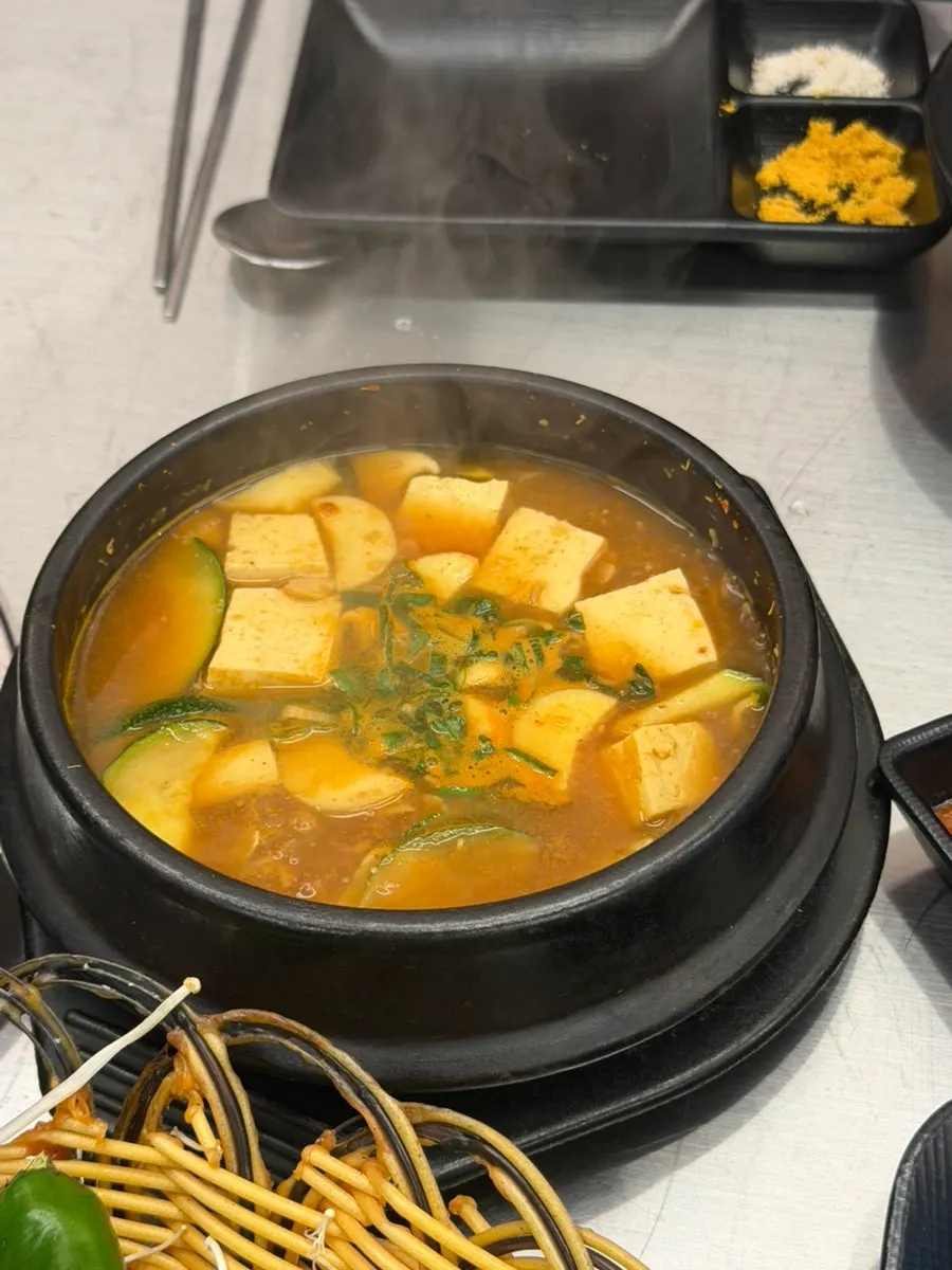 Grilled garlic and meat on the cauldron lid